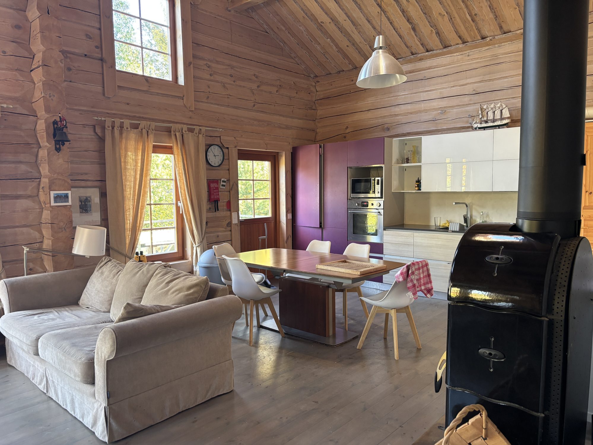 Open log cottage interior with a living area, dining table and kitchen