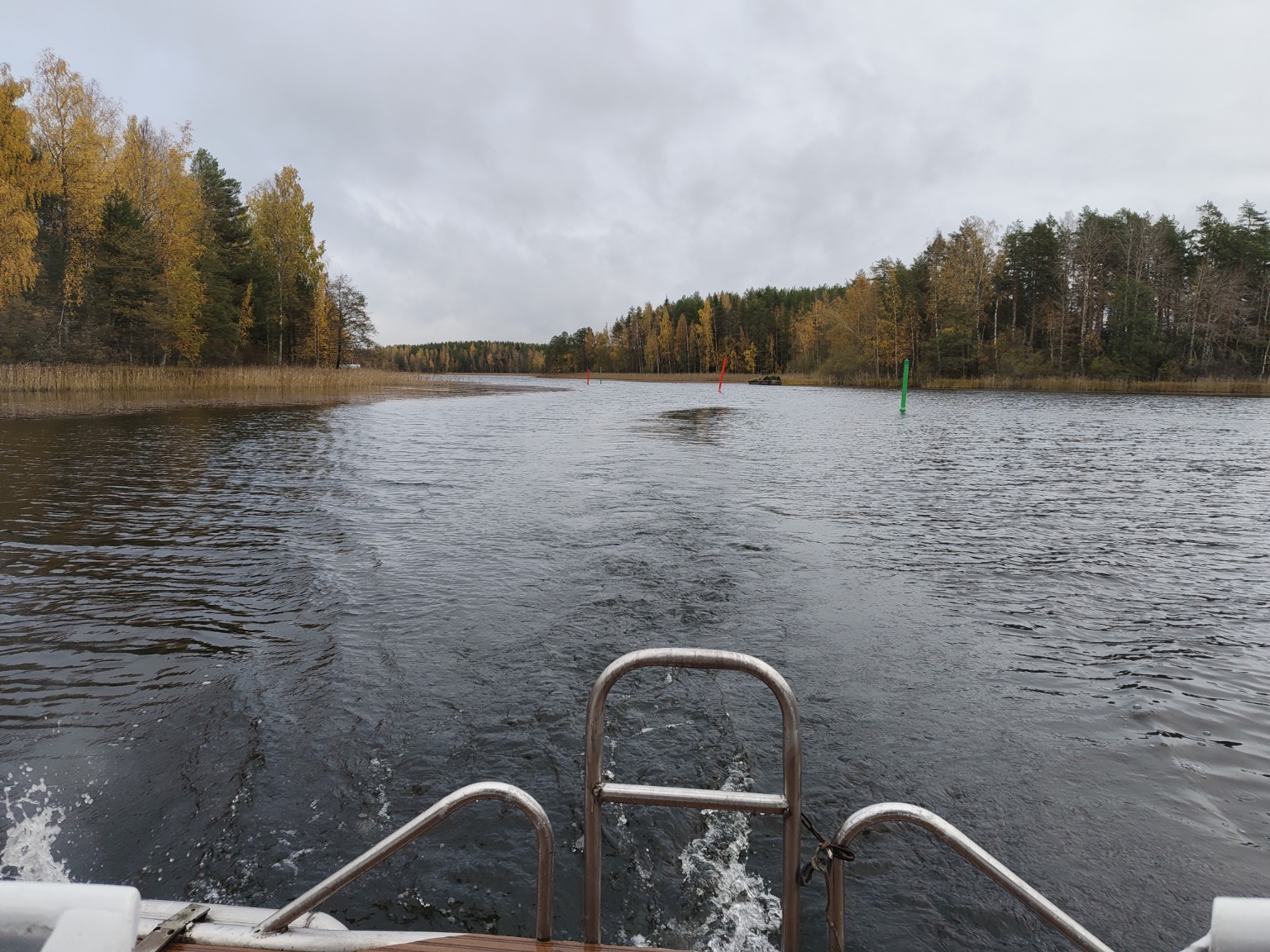 View from a boat across a Finnish waterway lined with autumn birches in October