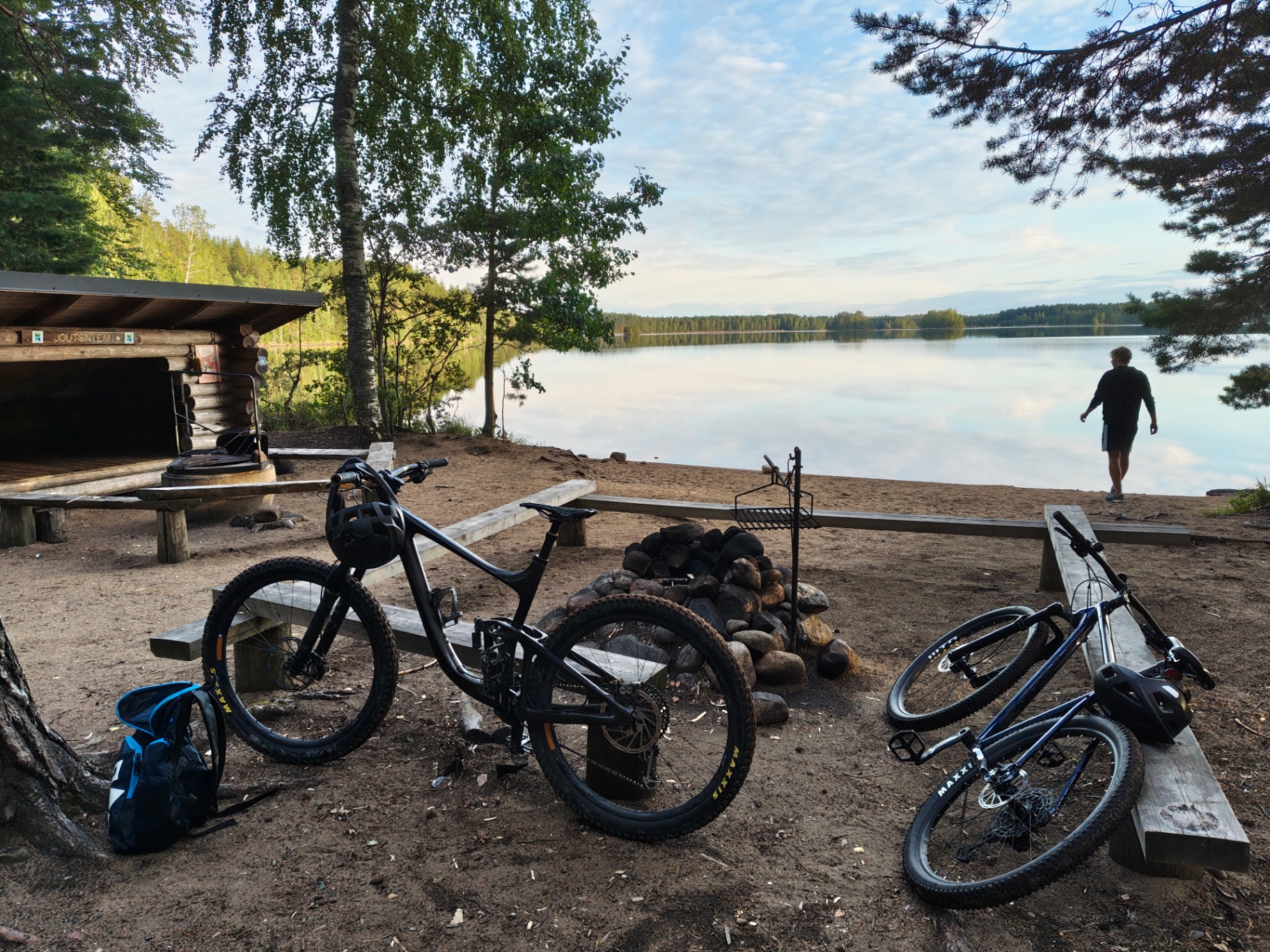 Bicicletas en un área de descanso con fuego junto a un lago finlandés