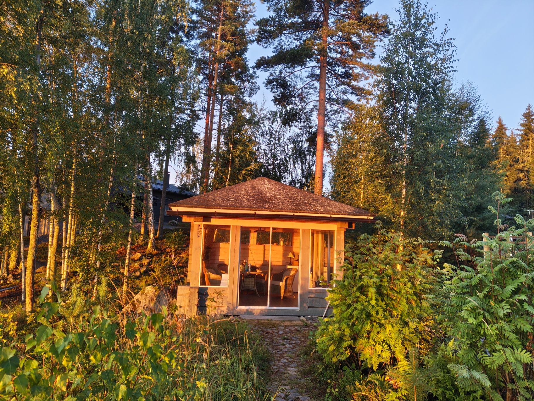 Cabaña de madera finlandesa bajo la luz dorada de una tarde de verano