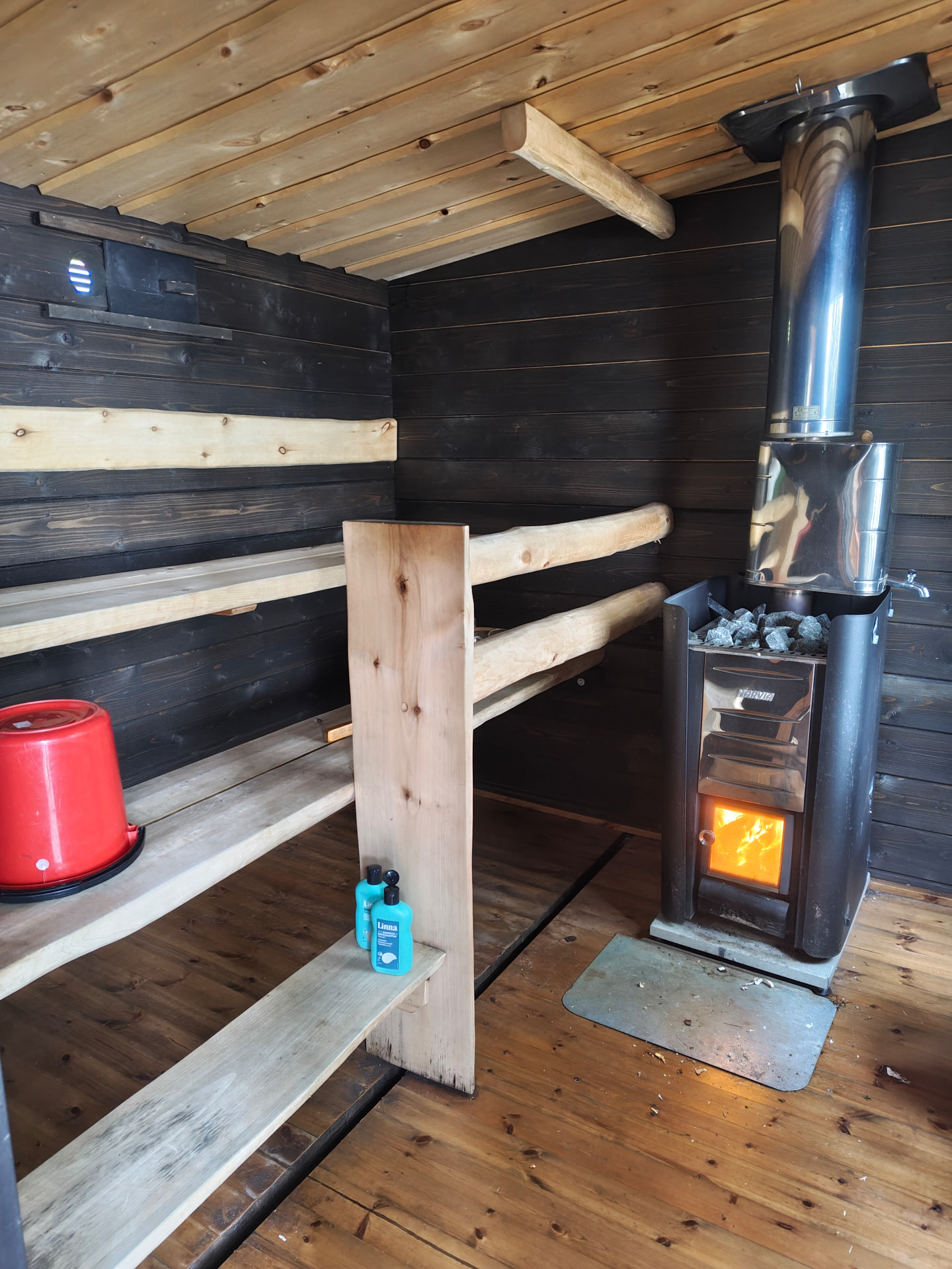 Sauna finlandesa auténtica calentada con leña junto a un lago en verano