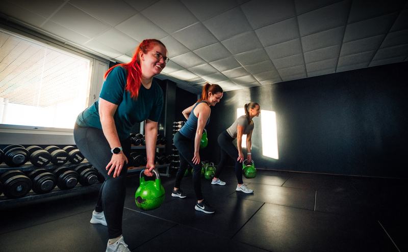 Small group exercise class with light kettlebells guided by an instructor