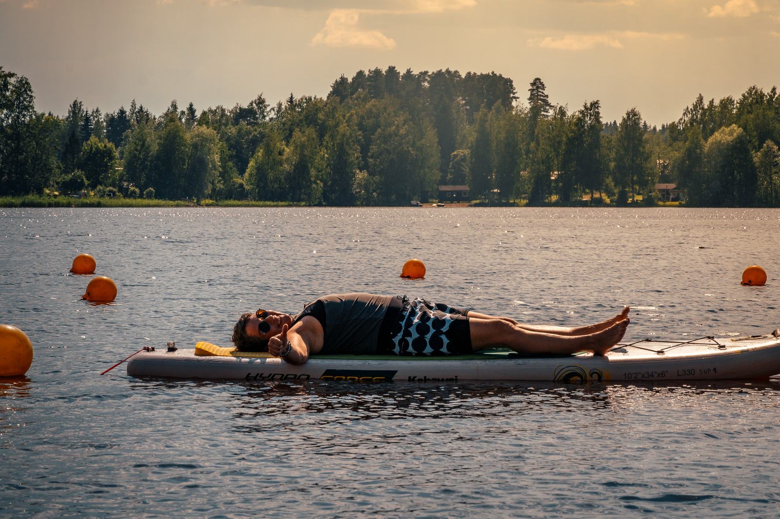 Stand-up-Paddling auf dem ruhigen Wasser des Kallavesi vor bewaldetem Ufer bei Kuopio
