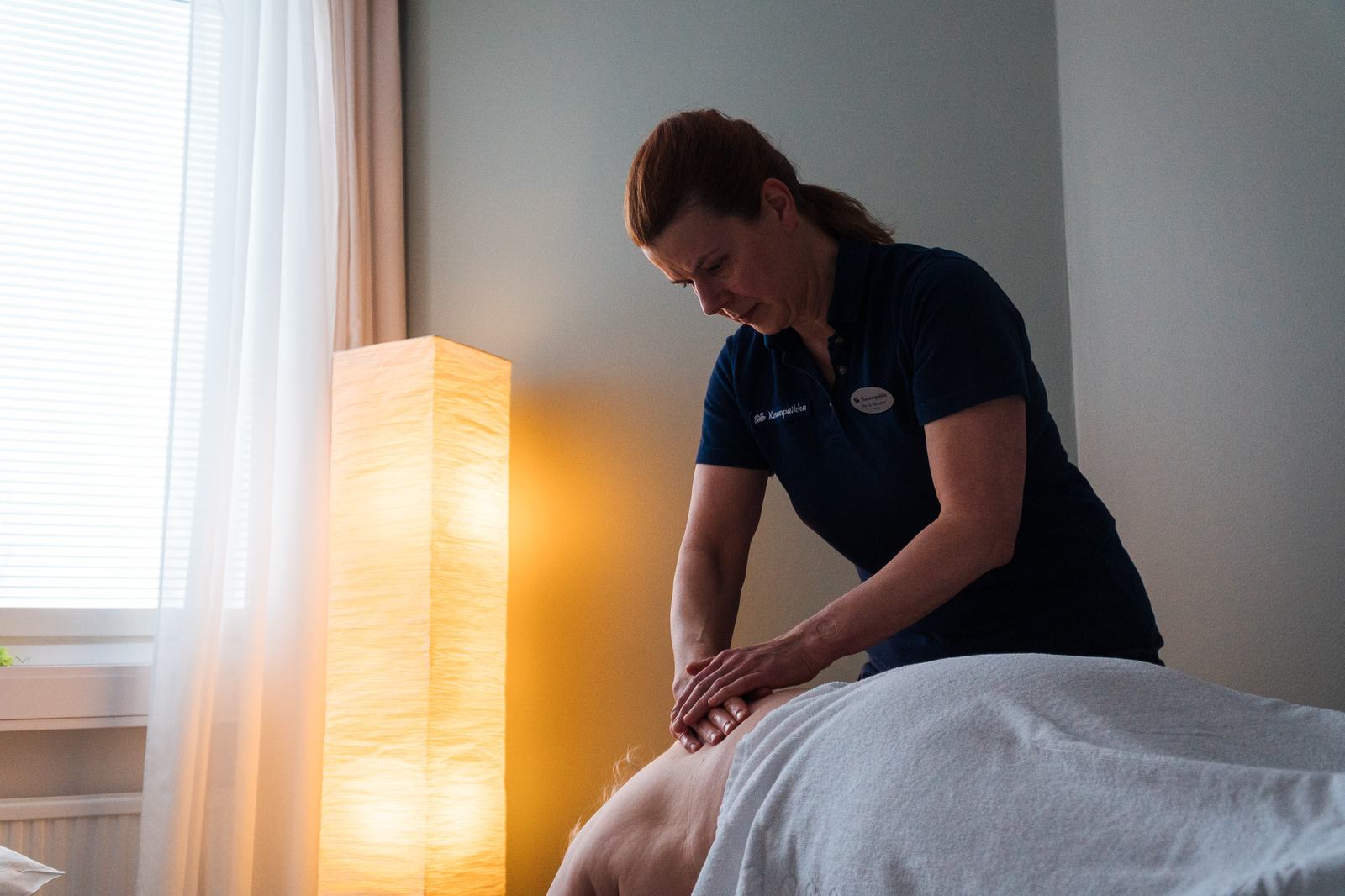 Therapist giving a relaxing back massage in a calm treatment room