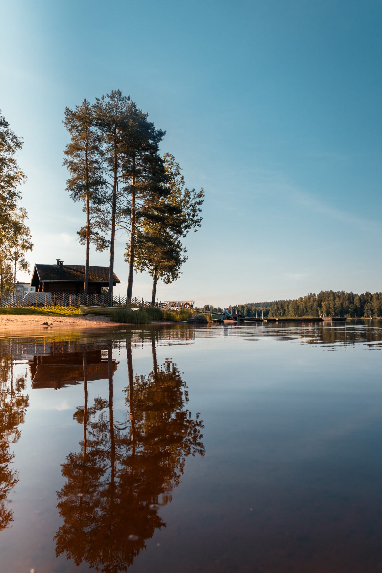 Calm lake water at Kallavesi in the late evening, with soft light over the forested opposite shore